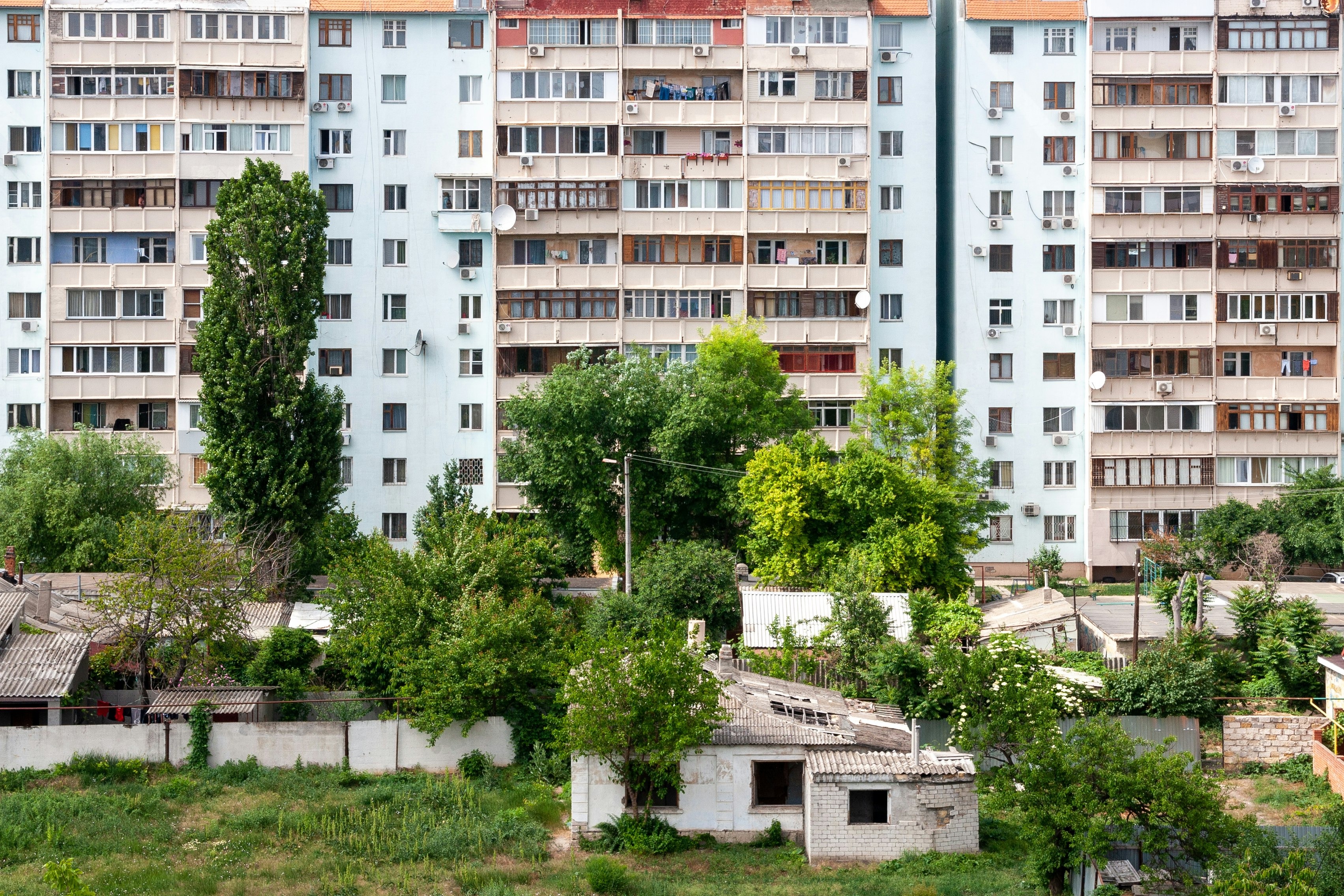 white and brown concrete building near green trees during daytime